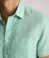 Model is wearing UNTUCKit solid ming green cameron shirt. 