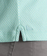 Model is wearing UNTUCKit Chen wrinkle free polo in bright green foulard print. 