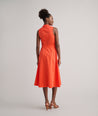 Model is wearing UNTUCKit Codelia dress in solid orange. 