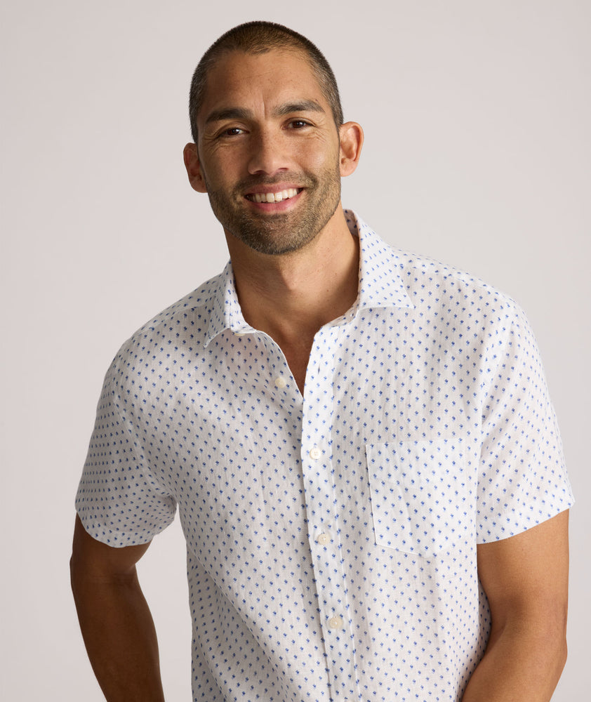 Model is wearing UNTUCKit Dixon short sleeve shirt with white grounded Dimond print. 
