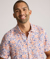 Model is wearing UNTUCKit Ellsworth Short Sleeve shirt in orange and blue floral. 