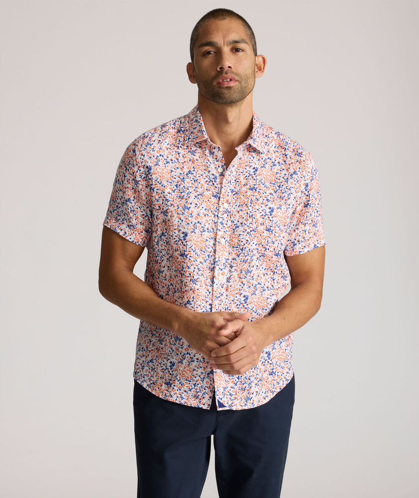 Model is wearing UNTUCKit Ellsworth Short Sleeve shirt in orange and blue floral. 