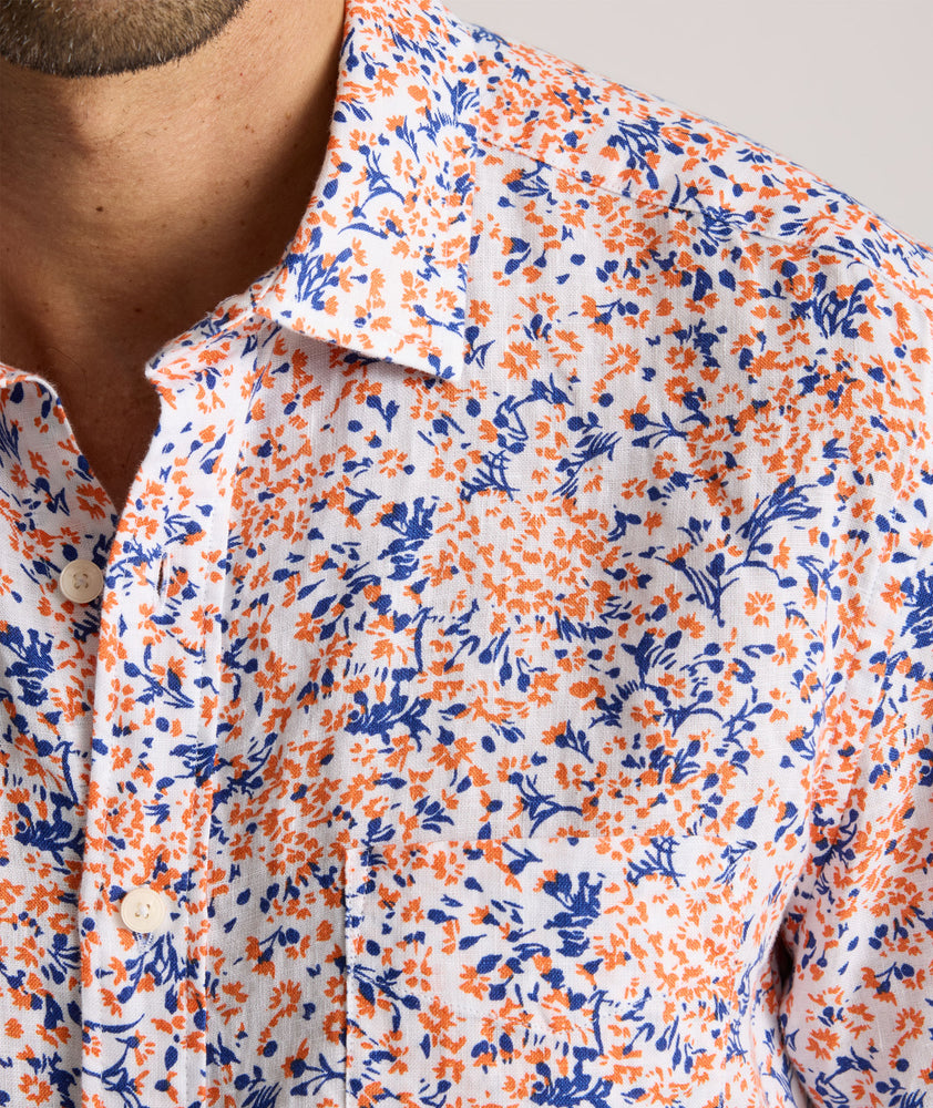 Model is wearing UNTUCKit Ellsworth Short Sleeve shirt in orange and blue floral. 