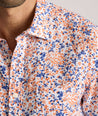 Model is wearing UNTUCKit Ellsworth Short Sleeve shirt in orange and blue floral. 