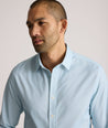 Model is wearing UNTUCKit Falkirk performance shirt in blue print. 