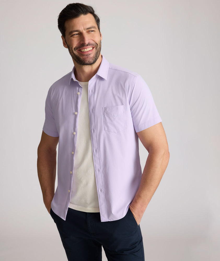 Model is wearing UNTUCKit Gironde short sleeve performance  shirt in purple. 