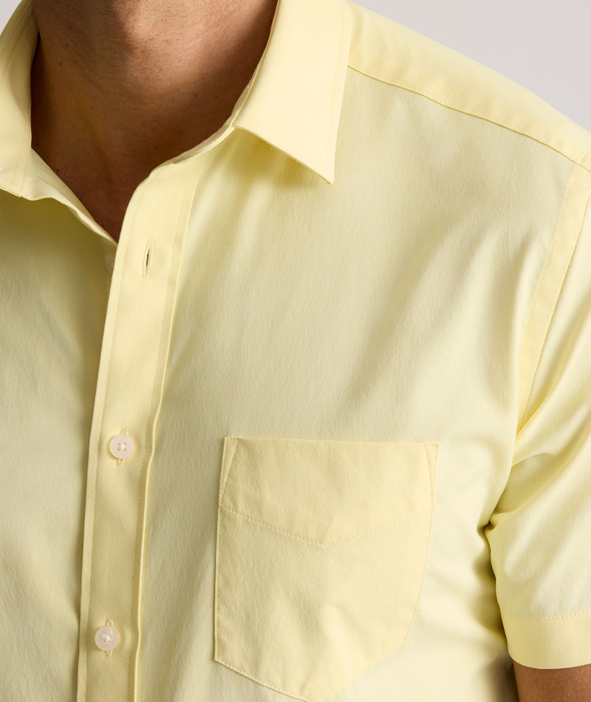 Model is wearing UNTUCKit Gironde short sleeve performance  shirt in light yellow. 