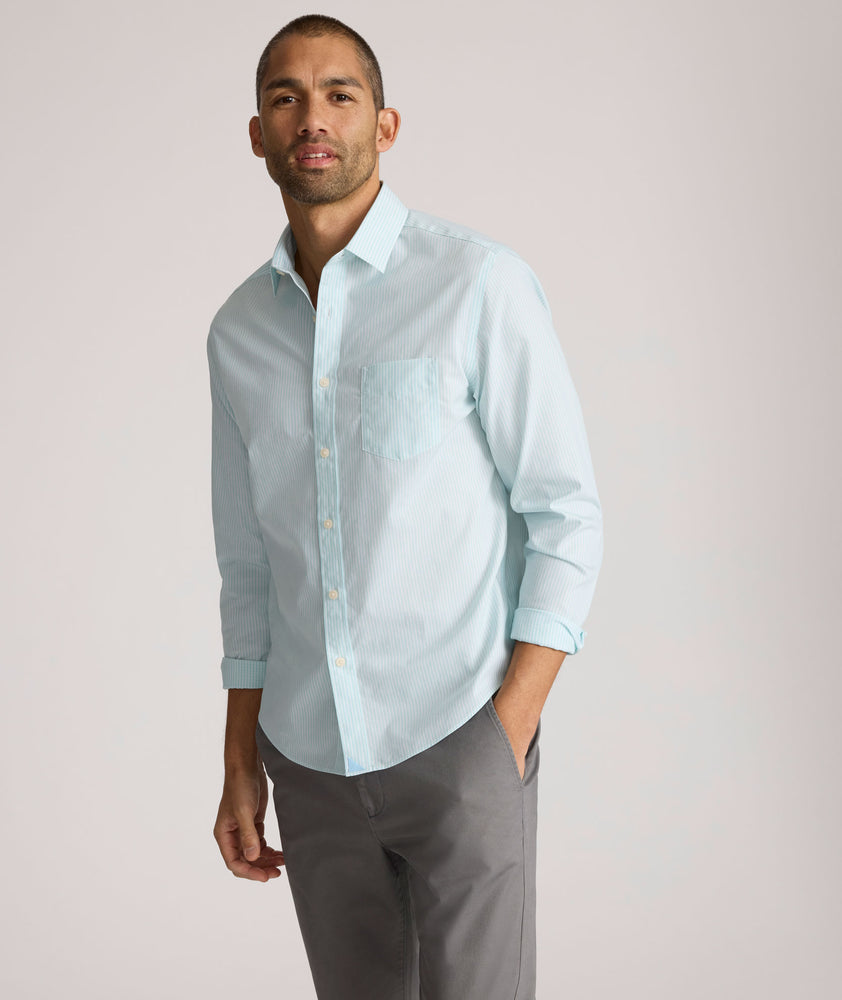 Model is wearing UNTUCKit Ormsby wrinkle-free shit in stripe blue. 