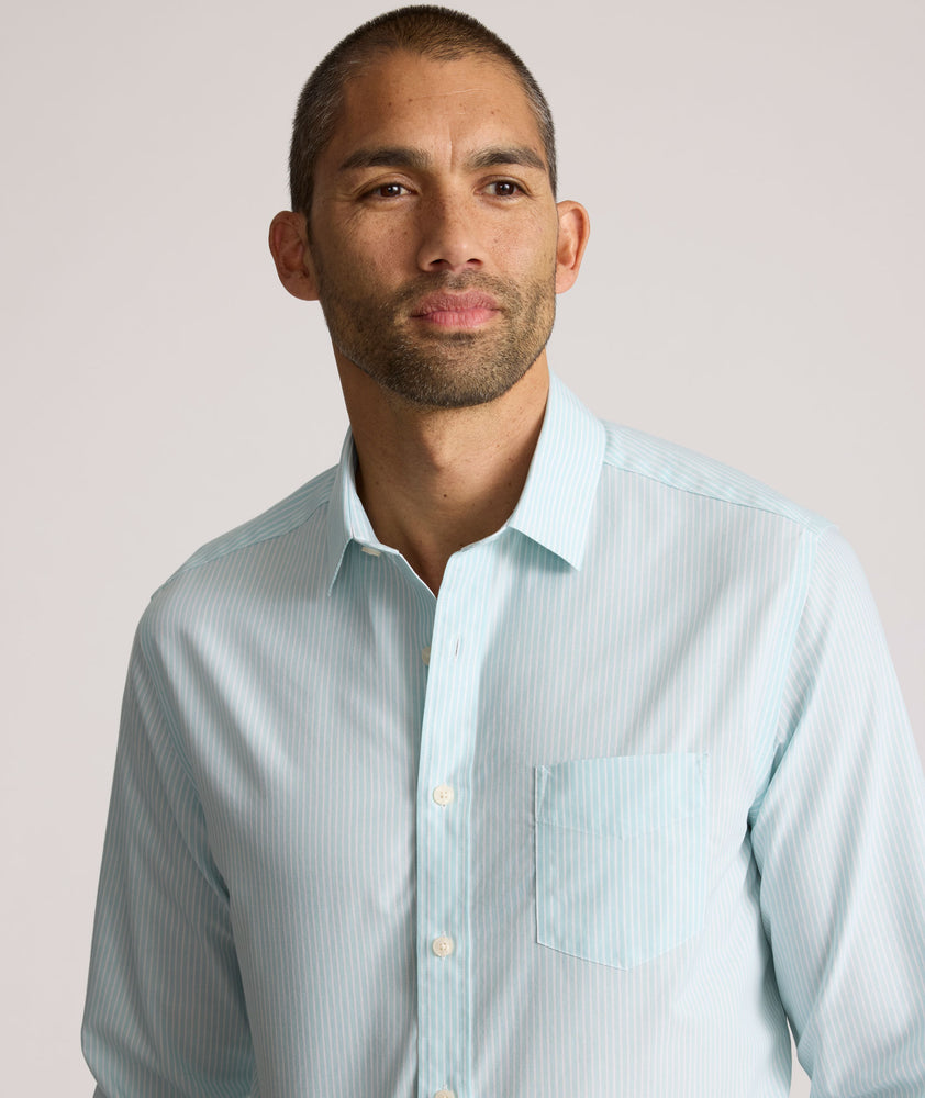 Model is wearing UNTUCKit Ormsby wrinkle-free shit in stripe blue. 
