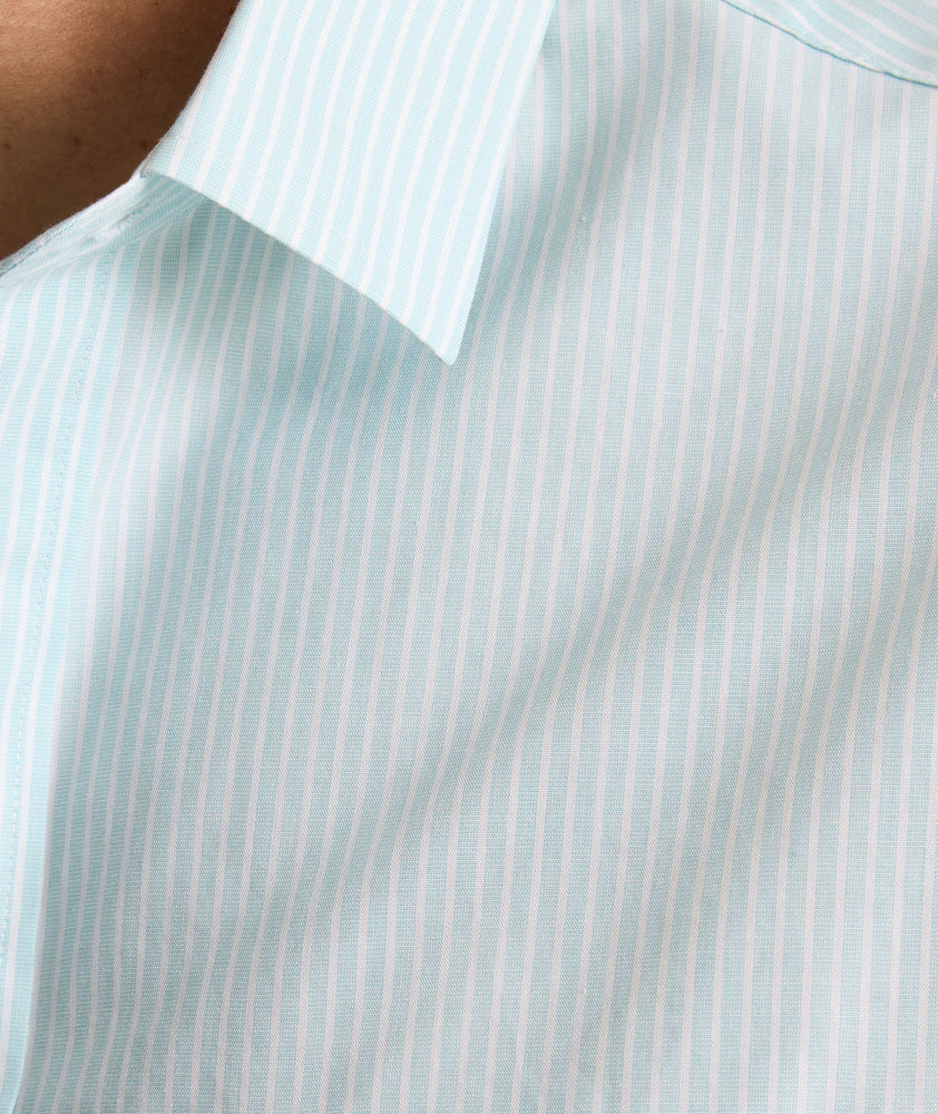 Model is wearing UNTUCKit Ormsby wrinkle-free shit in stripe blue. 