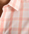 Model is wearing UNTUCKit ravenswood wrinkle free plaid plaid shirt in orange. 