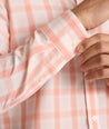 Model is wearing UNTUCKit ravenswood wrinkle free plaid plaid shirt in orange. 