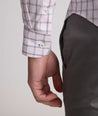 Model is wearing UNTUCKit Raynard cottentek shirt in pink windowpane. 