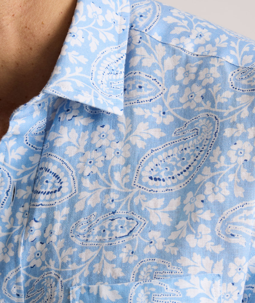 Model is wearing UNTUCKit Turner short sleeve linen shirt in light blue print. 