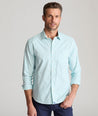 Model is wearing UNTUCKit Wells in light blue and green check. 