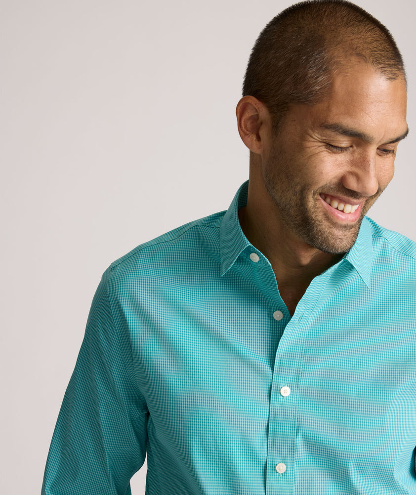 Model is wearing UNTUCKit Yorksley performance shirt in in teal tiny gingham. 