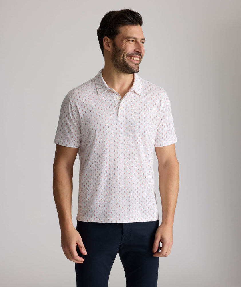 Model is wearing UNTUCKit Zandt Printed Performance Polo in White Coral.
