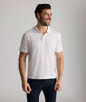 Model is wearing UNTUCKit Zandt Printed Performance Polo in White Coral.