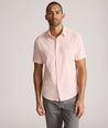 Model is wearing UNTUCKit zeller performance short sleeve shirt in pink geo. 